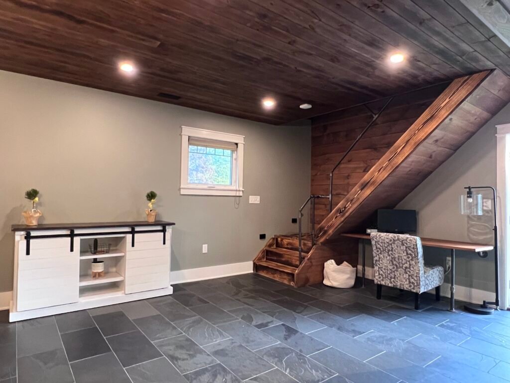 Rustic wood staircase and workspace area with slate floors at The Wayback Cleveland vacation rental near Chagrin Falls
