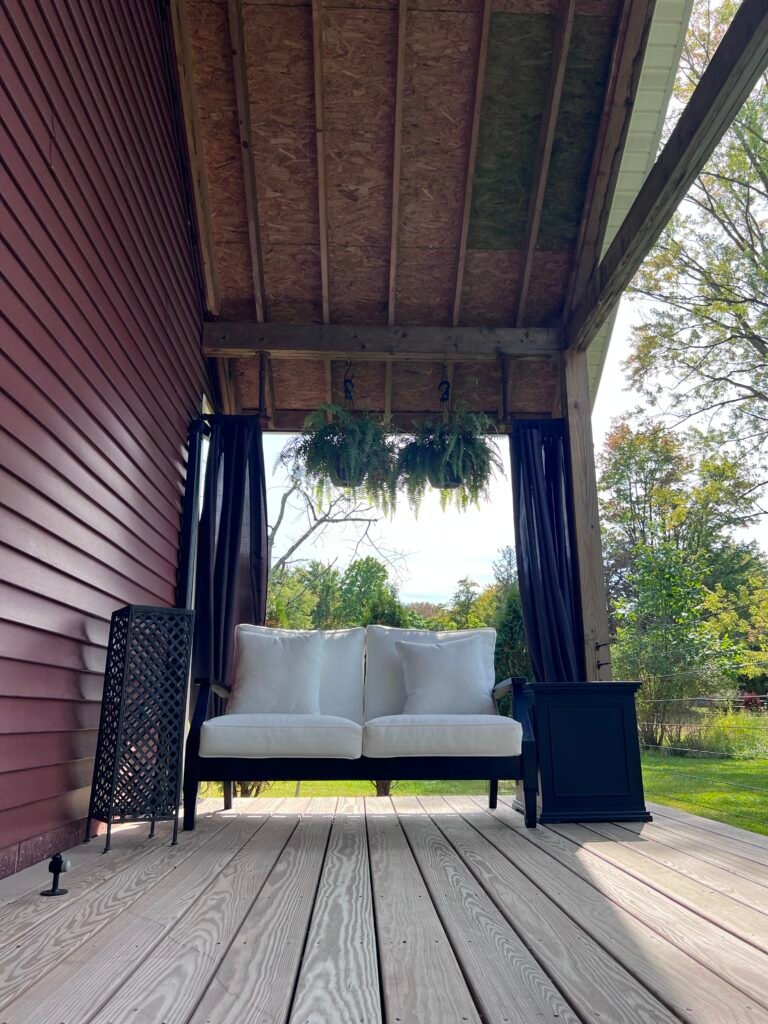 Covered porch seating area at The Wayback vacation rental near Cuyahoga Valley National Park