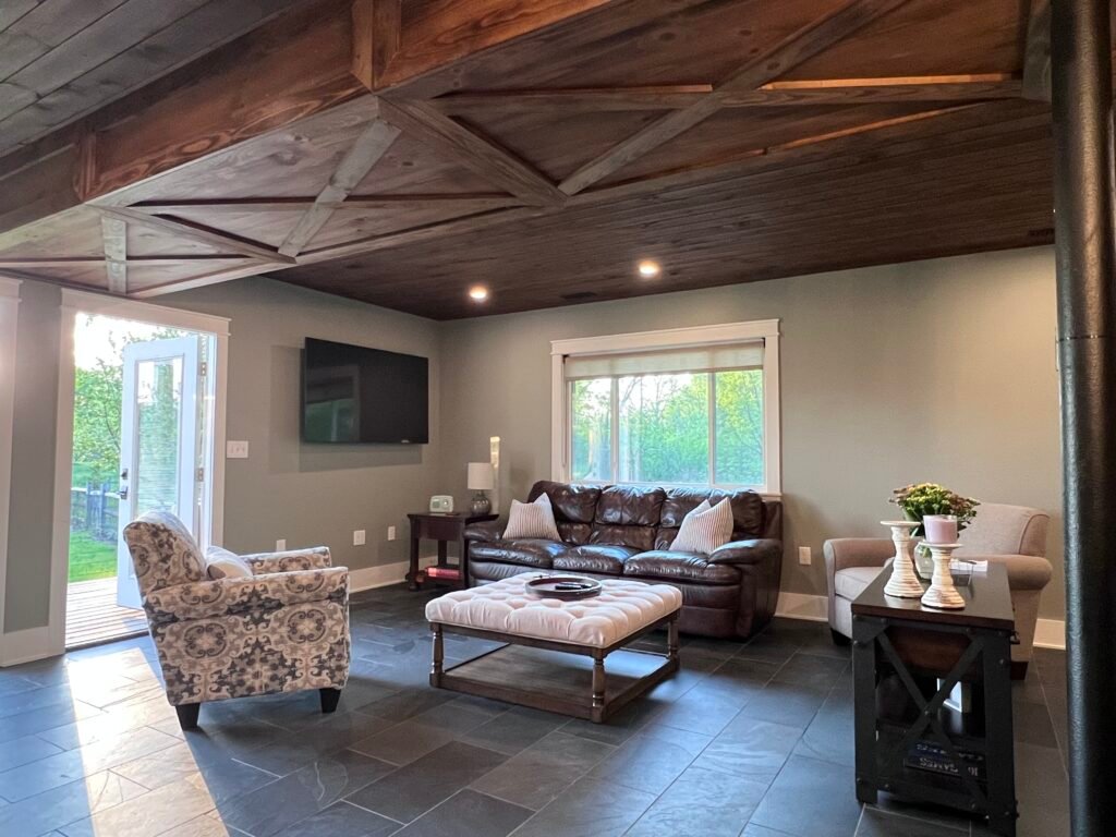 Spacious first floor living room with wood ceiling and slate floors at The Wayback Cleveland vacation rental near Chagrin Falls